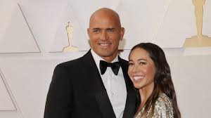 Who Is Kelly Slater Wife? Inspiring Facts About Kalani Miller Who Is Kelly Slater's Wife? All About Kalani Miller Introduction Kelly Slater wife is Kalani Miller, an American entrepreneur, model, and swimwear designer born on July 25, 1987, in San Clemente, California, United States. Kelly Slater is a legendary American professional surfer and 11-time World Surf League champion who is widely regarded as one of the greatest surfers of all time. Many fans search for information about Kelly Slater wife, but the story is slightly different. Slater has been in a long-term relationship with Kalani Miller for many years, and the couple has built a strong life together while maintaining a relatively private relationship. From Kalani's successful career in the fashion industry to her passion for surfing and entrepreneurship, she has created her own identity beyond being linked to the surfing icon. In this article, we'll explore Kalani Miller's background, career, relationship with Kelly Slater, family life, social media presence, and some interesting facts about the woman who has been by the surfing champion's side for nearly two decades. Who Is Kalani Miller? Kalani Miller is an American entrepreneur, fashion designer, model, and social media personality best known for her swimwear business and her long-term relationship with Kelly Slater. She was born on July 25, 1987, in San Clemente, California, a coastal city known for its strong surfing culture. Growing up near the ocean had a major influence on Kalani's life. She was raised in a family that loved surfing and outdoor activities. Her mother, Charlene, has Hawaiian roots, while her father, Jim Miller, is from California. Kalani grew up alongside her siblings Oleema, Hana, and Jason. As a child, she spent much of her time surfing, painting, and modeling. These early interests eventually shaped both her personal and professional life. Her love of the ocean later became the inspiration behind her successful swimwear brand. Education also played an important role in Kalani's development. She attended the University of California, Santa Barbara, where she earned a degree in Communications. Her educational background helped her build valuable business and marketing skills that would later support her entrepreneurial journey in the fashion industry. Kalani Miller's Career & Professional Life Kalani Miller has built an impressive career as an entrepreneur and fashion designer. While many people know her because of her relationship with Kelly Slater, she has achieved significant success on her own. Her most notable business venture is MIKOH, a swimwear brand she co-founded with her sister Oleema Miller in 2008. The brand quickly gained popularity thanks to its stylish, high-quality swimwear designs inspired by beach culture and global travel. At MIKOH, Kalani focuses largely on business operations, marketing, and brand development, while her sister contributes to the creative and design side of the company. Together, they have transformed the brand into a respected name in the swimwear industry. In addition to her work in fashion, Kalani has also worked as a model and social media influencer. Her surfing lifestyle, travel experiences, and beach-inspired content have attracted a dedicated audience online. Kalani's professional success stems from her understanding of the surfing and beach lifestyle market. Her products appeal to women who enjoy travel, fashion, and ocean-inspired living. Although exact figures vary across reports, Kalani's net worth is estimated to be in the millions thanks to her fashion business, brand partnerships, and entrepreneurial ventures. Her continued involvement in MIKOH remains a major source of her success. How Did Kelly Slater and Kalani Miller Meet? The love story between Kelly Slater and Kalani Miller began in the mid-2000s within the surfing industry. According to various reports, the couple first met at the ASR Surf Trade Show in San Diego, California. At the time, Kalani was working with surf-related brands while Kelly was already one of the biggest names in professional surfing. Their shared passion for surfing and ocean culture created an immediate connection. Kalani later recalled that seeing Kelly for the first time left a strong impression on her. Over time, friendship developed into a romantic relationship. The couple reportedly began dating around 2008 and have remained together ever since. Unlike many celebrity couples, Kelly and Kalani have generally kept their relationship private. They occasionally share photos and tributes on social media but rarely discuss intimate details publicly. Throughout their relationship, Kalani has traveled extensively with Kelly to surfing competitions and events around the world. Their shared love for adventure, travel, and the ocean has helped strengthen their bond. Although there have been rumors about marriage over the years, the couple has largely chosen to keep their relationship status private, focusing instead on building a lasting partnership and family together. Marriage & Wedding Details Many online searches use the term Kelly Slater wife, but publicly available information indicates that Kelly Slater and Kalani Miller have not officially confirmed a marriage. Despite this, they have been one of surfing's most admired couples for nearly two decades. Their long-lasting relationship often leads fans to refer to Kalani as Kelly Slater's wife. The couple has attended numerous industry events, surf competitions, charity functions, and social gatherings together throughout the years. Their relationship has remained remarkably stable despite Kelly's demanding travel schedule and global fame. Rather than focusing on a public wedding ceremony, Kelly and Kalani have prioritized building a strong partnership based on shared interests, mutual respect, and family values. Their enduring relationship serves as an example of how celebrity couples can maintain privacy while still enjoying a successful life together. Children & Family Life Family has become an increasingly important part of Kelly Slater and Kalani Miller's lives. Kelly is the father of daughter Taylor from a previous relationship. Taylor was born in 1996 and has maintained a close relationship with her father. In recent years, Kelly and Kalani expanded their family together. Reports confirmed that the couple welcomed a child after many years of dating, marking an exciting new chapter in their lives. The family spends much of their time enjoying outdoor activities, surfing, traveling, and exploring beach destinations around the world. Although Kelly is one of the most recognizable figures in surfing history, he and Kalani have worked hard to keep their family life relatively private. They occasionally share family moments online but generally avoid exposing their children to excessive public attention. Their balanced approach allows them to enjoy family life while maintaining successful careers. Kalani Miller on Social Media Kalani Miller maintains an active presence on Instagram, where she shares content related to surfing, travel, fashion, wellness, family life, and entrepreneurship. Her account attracts well over 100,000 followers who enjoy her beach-inspired lifestyle content. Many of her posts feature beautiful coastal locations, surfing adventures, behind-the-scenes looks at her swimwear business, and occasional glimpses into her relationship with Kelly Slater. Kalani's social media reflects her authentic personality and passion for ocean living, making her a popular figure among surfing and fashion enthusiasts alike. Quick Facts Table Detail Info Full Name Kalani Miller Date of Birth July 25, 1987 Nationality American Profession Entrepreneur, Fashion Designer, Model Married to Long-term partner Kelly Slater Marriage Year Not publicly confirmed Children One child with Kelly Slater Net Worth Estimated in the millions (various reports) FAQ Section Q: What is Kelly Slater's wife name? A: Kelly Slater is in a long-term relationship with Kalani Miller. Although often referred to as Kelly Slater's wife, a marriage has not been publicly confirmed. Q: How old is Kalani Miller? A: Kalani Miller was born on July 25, 1987. As of 2026, she is 38 years old. Q: What does Kalani Miller do for a living? A: Kalani Miller is an entrepreneur, fashion designer, and co-founder of the swimwear brand MIKOH. She is also a model and social media personality. Q: When did Kelly Slater and Kalani Miller get married? A: There is no publicly confirmed information indicating that Kelly Slater and Kalani Miller are married. They have been together for many years. Q: How many kids do Kelly Slater and Kalani Miller have? A: Kelly Slater and Kalani Miller share one child together. Kelly also has an older daughter, Taylor, from a previous relationship. Conclusion Kalani Miller is much more than the woman often described as Kelly Slater wife. She is a successful entrepreneur, talented fashion designer, passionate surfer, and devoted mother. Through her swimwear brand MIKOH and her involvement in the surfing community, she has built a respected career of her own. Her long-lasting relationship with Kelly Slater has captured the interest of fans around the world, but what truly stands out is the couple's commitment to family, privacy, and shared values. Together, they continue to inspire many people through their love of the ocean, adventure, and each other. kelly slater wife